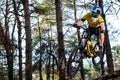 Professional Cyclist in Yellow T-shirt and Helmet Riding the Mountain Bike in Forest. Extreme Sport Concept. Royalty Free Stock Photo