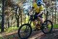 Professional Cyclist in Yellow T-shirt and Helmet Riding the Mountain Bike in Forest. Extreme Sport Concept. Royalty Free Stock Photo