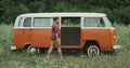 Professional dancer , in the middle of field dacing in front of a retro van.