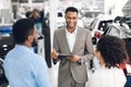 Professional Dealer Talking With Customers Showing Automobiles In Dealership Store