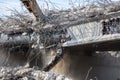 Professional demolition of reinforced concrete structures using industrial hydraulic hammer. Rods of metal fittings. Wreckage and