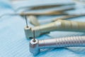 Professional dental tools on a doctor`s desk. Handpieces and other tools on a blue background. Soft focus, shallow depth of field Royalty Free Stock Photo