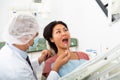 Dentist examines woman mouth at dental clinic