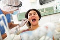 Dentist examines woman mouth at dental clinic