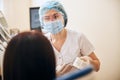 Young attentive stomatologist looking at her patient