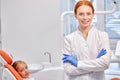 Professional Dentist Orthodontist Posing At Camera At Work Place, With Child Patient