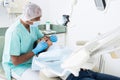 Professional dentist performing teeth treatment to woman in clinic