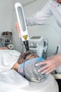 dermatologist wearing a medical mask and rubber gloves applies a mask to a client& x27;s face.