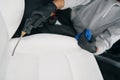 Professional detailer drying automotive seat seams with compressed air