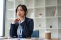 A professional and determined Asian businesswoman sits at her desk Royalty Free Stock Photo