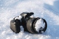 professional digital slr photo camera lies in a snowdrift in snow in winter Royalty Free Stock Photo