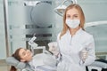 Dentist in medical mask posing with patient.