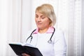 Professional doctor notes in medical journal. Woman physician or pharmacist in white coat writing in paper notebook. Focused