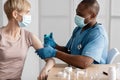 Professional doctor or nurse giving flu or COVID-19 injection to patient Royalty Free Stock Photo