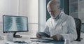 Professional doctor checking medical records in his office