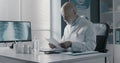 Professional doctor checking medical records in his office