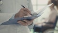 Doctor writing medical records and patient in a wheelchair Royalty Free Stock Photo