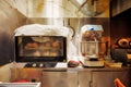 Professional dough kneader or kneading machine and an oven filled with bread in an industrial kitchen