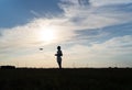 A professional drone pilot controls it against the sunset sky. Copter operator silhouette Royalty Free Stock Photo