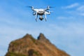 Professional drone quad copter DJI Phantom 4 Pro with digital camera flight in deep blue sky and photographs beautiful mountain ro Royalty Free Stock Photo
