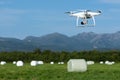 Professional drone quad copter DJI Phantom 4 Pro flight, monitoring using camera 4K over field with rolls of hay on sunny dry day Royalty Free Stock Photo