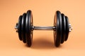 Professional dumbbell and weight plates over beige background. Black metal dumbbell with chrome silver handle. Gym Royalty Free Stock Photo