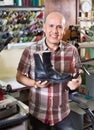 Professional efficient shoemaker heeling footwear on machine Royalty Free Stock Photo