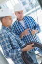 Professional electrician with student on construction site Royalty Free Stock Photo