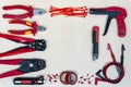 Red professional electrician tools on light wood background. Top view.