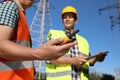 Electricians near high voltage towers, focus on hand with portable radio station