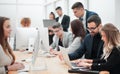 Professional employees work on computers in a modern office