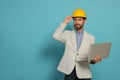 Professional engineer in hard hat with laptop on light blue background, space for text Royalty Free Stock Photo