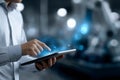 Engineer interacting with tablet in a modern industrial setting, showcasing advanced technology and innovation in a photorealistic Royalty Free Stock Photo
