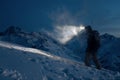 Professional expeditor commit climb on snowy mountains at night and lights the way with a headlamp. Wearing ski wear, backpack and Royalty Free Stock Photo