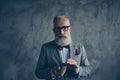 Professional, experienced, cunning, old gambler in tux with bow, glasses, shuffle deck of card, ready for game, standing over Royalty Free Stock Photo