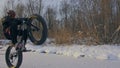 Professional extreme sportsman biker riding fat bike in outdoor. Cyclist ride in winter snow forest. Man does trial