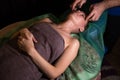 Professional facial massage. Male masseur makes procedures on a female face on a dark background Royalty Free Stock Photo