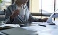 Professional female accountant holding coffee cup and checking financial reports Royalty Free Stock Photo