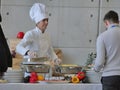 Professional female chef prepares buffet food for customers