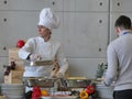 Professional female chef prepares buffet food for customers