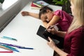 Professional female child psychologist working with a little preschool girl in a bright office. Woman makes notes Royalty Free Stock Photo