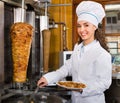 Professional female cook with grilled meat on spit for kebab Royalty Free Stock Photo