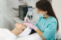 Professional female cosmetologist doing hydrafacial procedure in Cosmetology clinic. Doctor use hydra vacuum cleaner Royalty Free Stock Photo