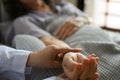 A professional female doctor or nurse checking an aged female patient`s pulse by hand Royalty Free Stock Photo