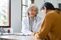 Professional female doctor talking, having a serious conversation with her young patient Royalty Free Stock Photo