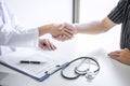 Professional female doctor in white coat shaking hand with patient after successful recommend treatment methods after results Royalty Free Stock Photo