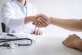 Professional female doctor in white coat shaking hand with patient after successful recommend treatment methods after results Royalty Free Stock Photo