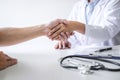 Professional female doctor in white coat shaking hand with patient after successful recommend treatment methods after results Royalty Free Stock Photo