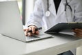 a professional female doctor working at her desk, using laptop and examining medical cases Royalty Free Stock Photo