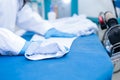 Professional female dry cleaner prepares a shirt for ironing